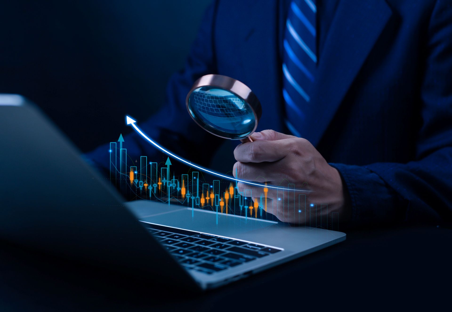 Mann analysiert Finanzdaten mit Lupe und Laptop