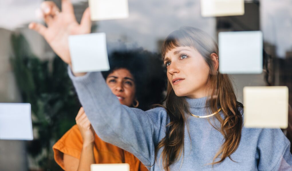 Frauen organisieren Ideen mit Haftnotizen | Seminarmanagement Software