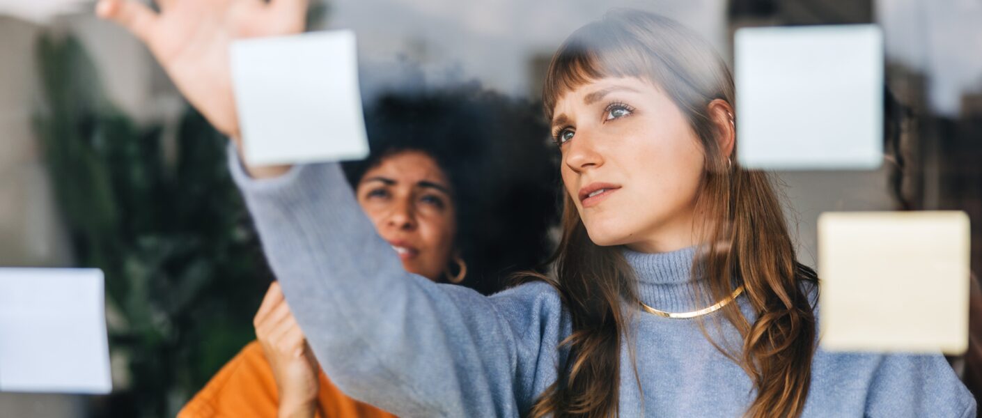 Frauen organisieren Ideen mit Haftnotizen | Seminarmanagement Software